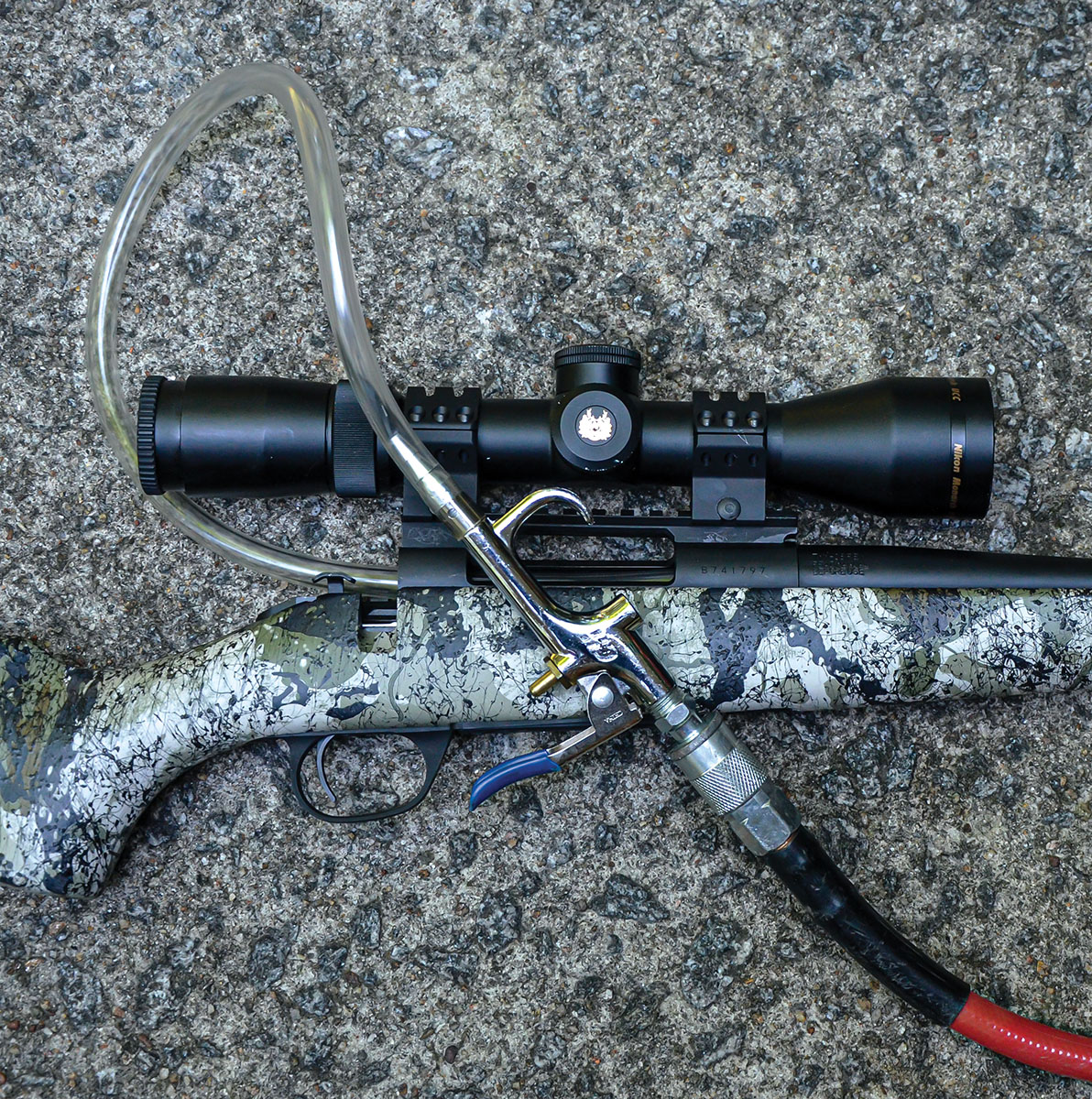 This air blow gun attaches to the hose of the compressor and a smaller plastic hose attached to it is small enough to enter the chamber of a barrel. Pulling its trigger allows air to flow from the collection tank of the compressor through the rifle barrel.